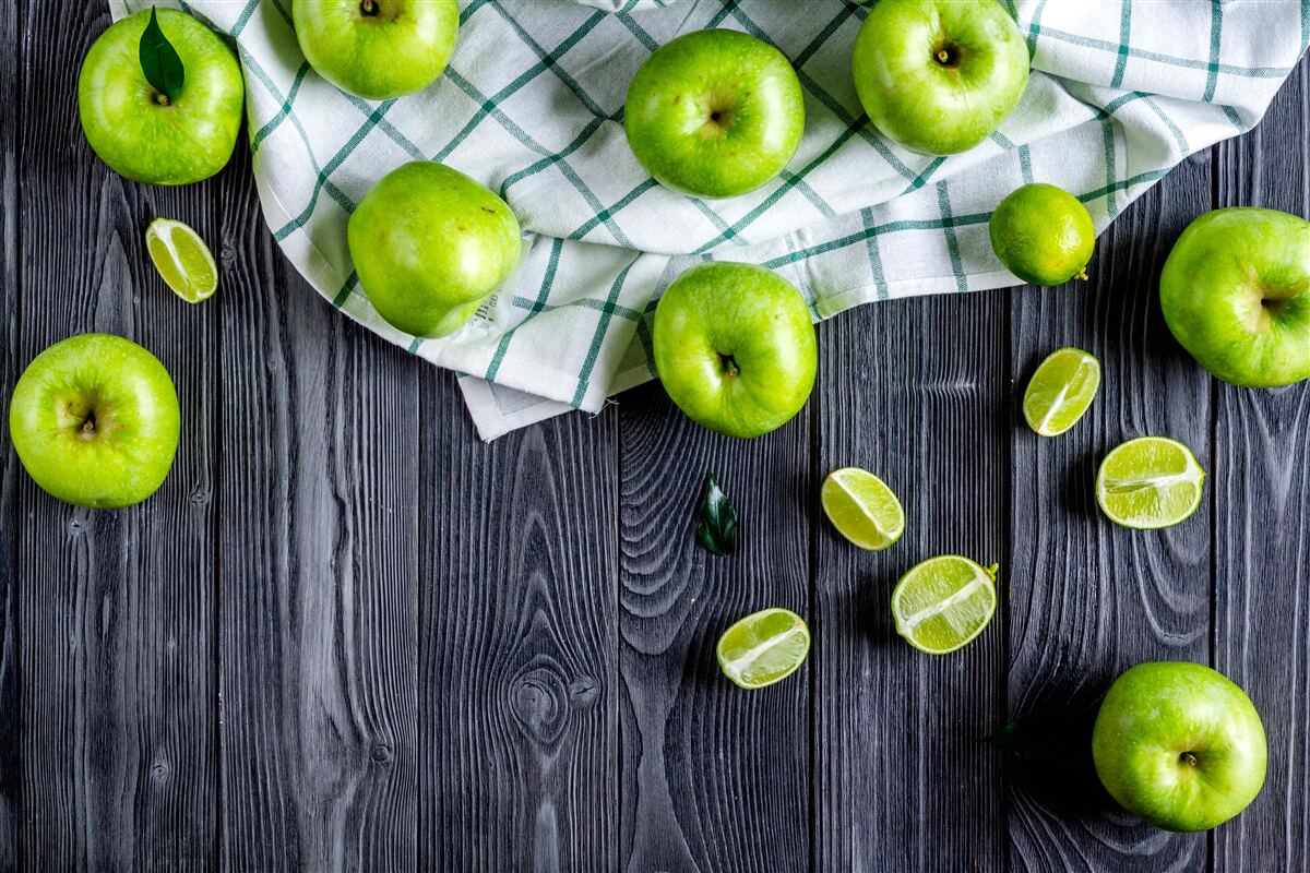 Papier peint des citrons verts et des pommes vertes sont sur la table