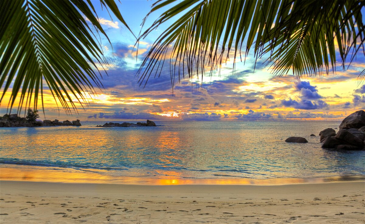 Papier peint le rivage est entouré d'un paisible coucher de soleil tropical