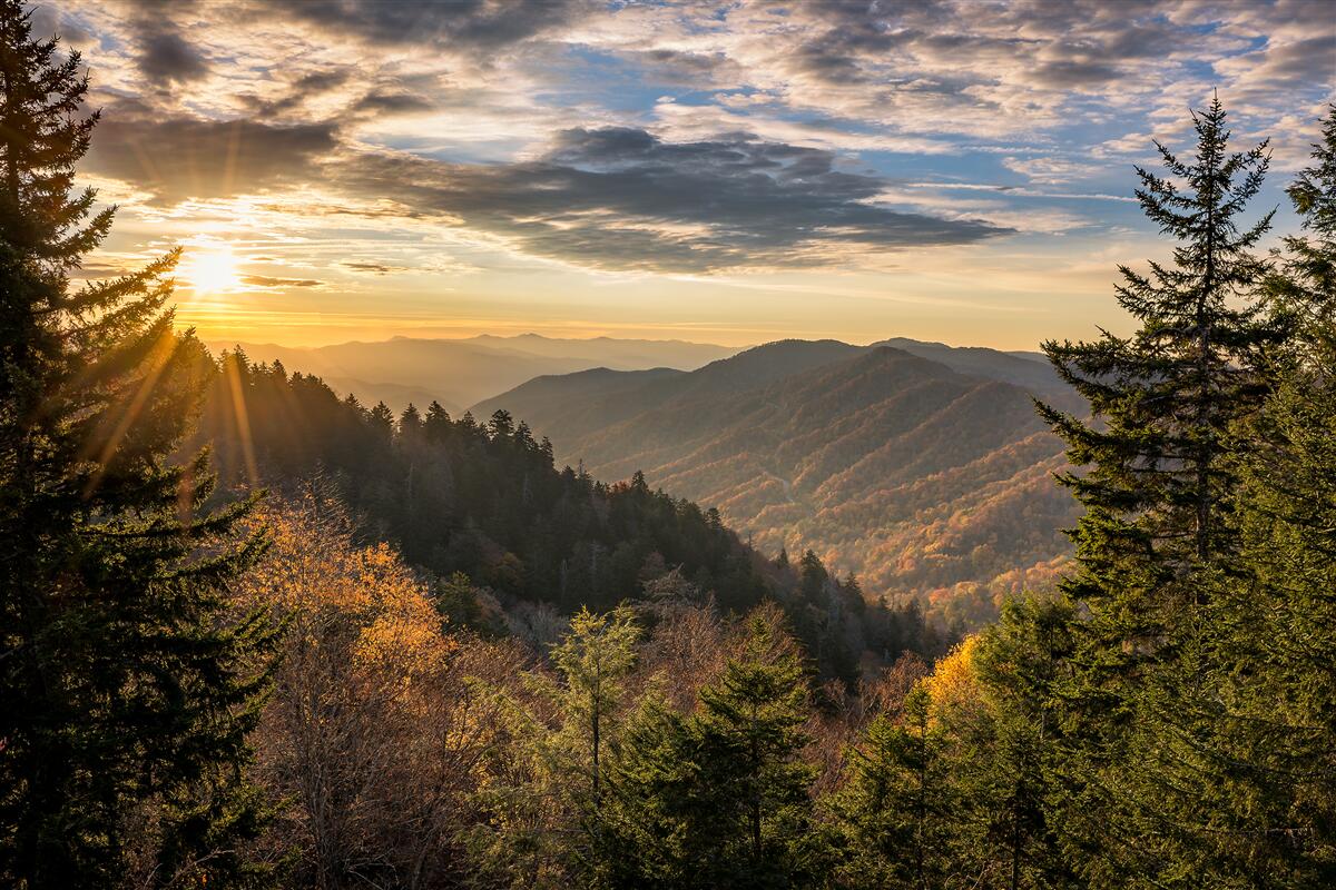Papier peint le soleil couchant sur les sommets des montagnes