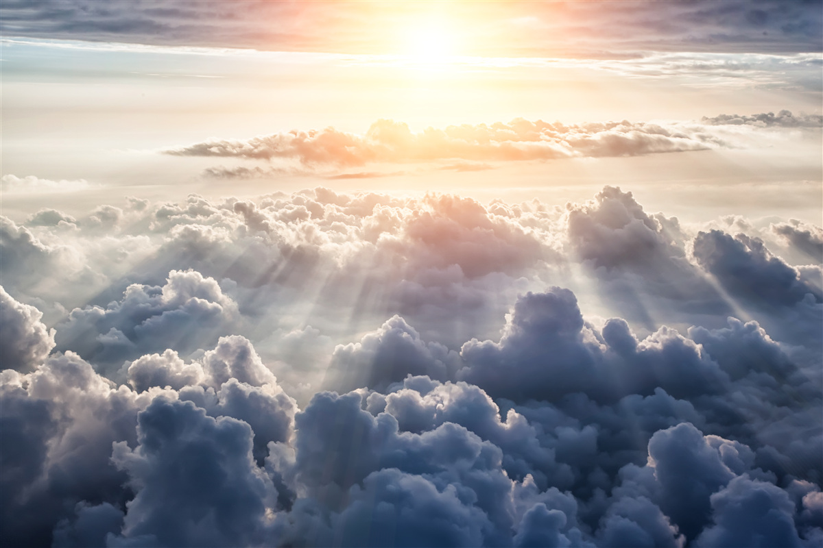 Papier peint lever de soleil sur des nuages denses