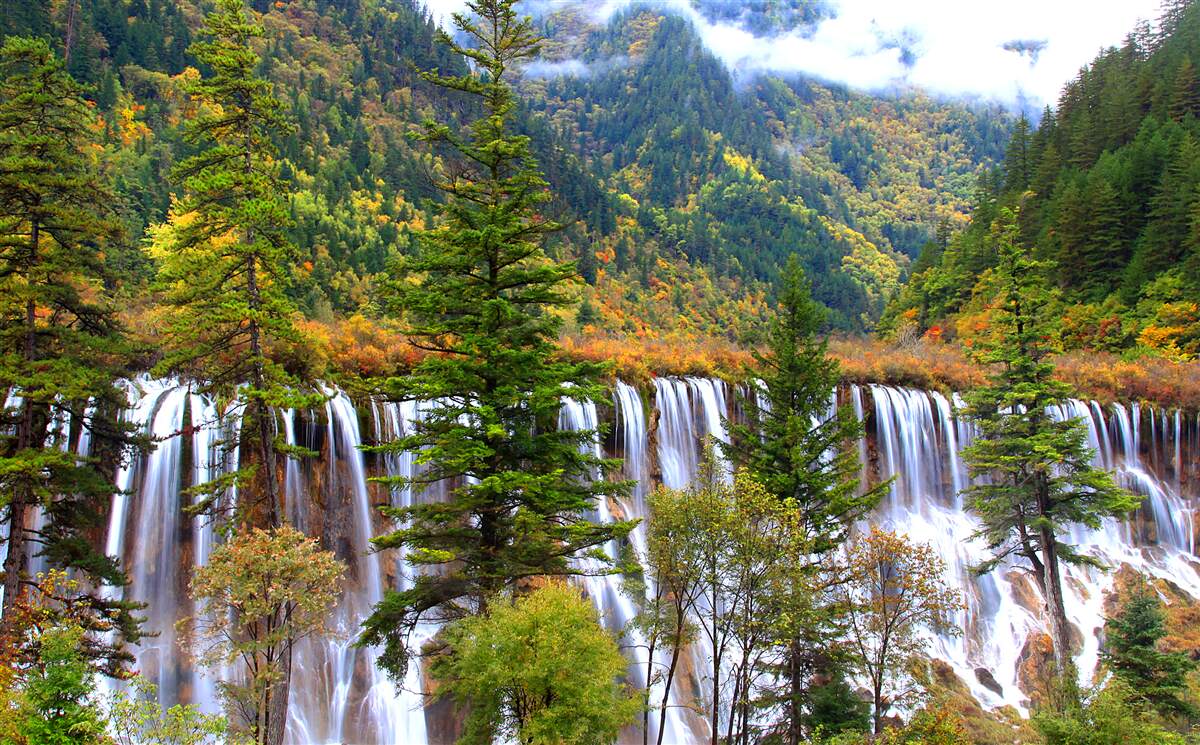Papier peint une énorme chute d'eau qui coule à flanc de montagne