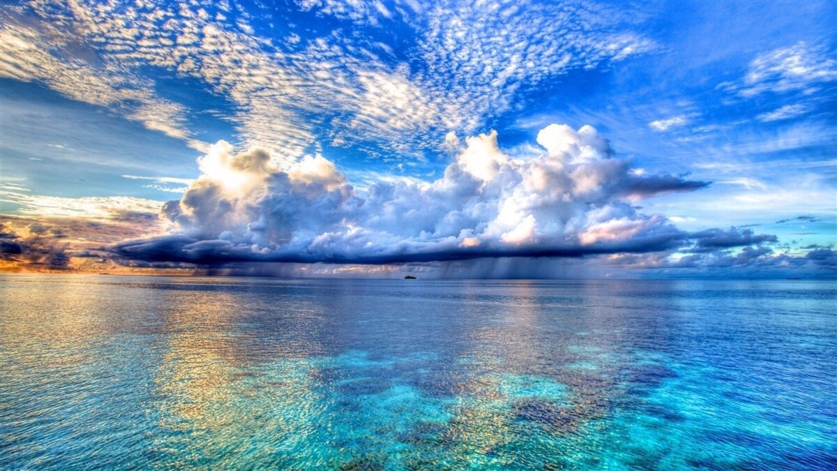 Papier peint les nuages flottent doucement sur la surface bleue de l'eau