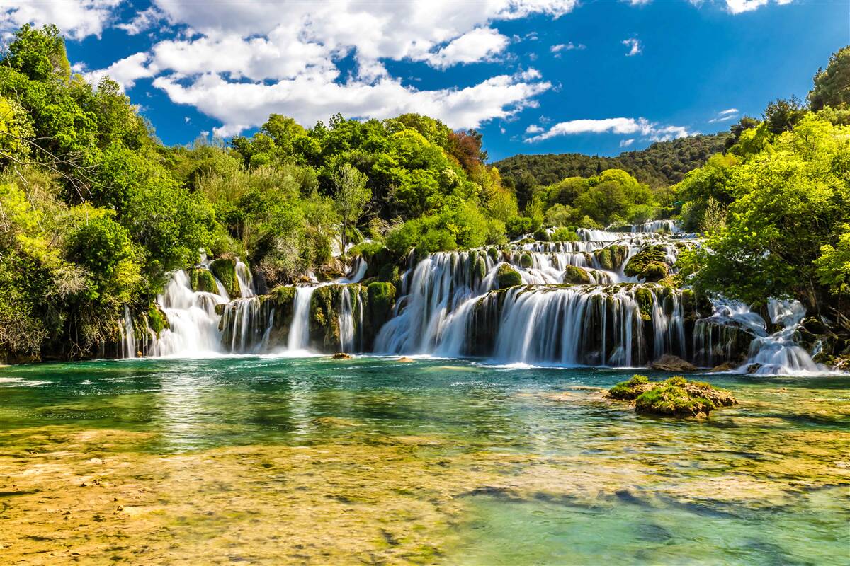 Papier peint une énorme chute d'eau qui s'écrase sur une île tropicale