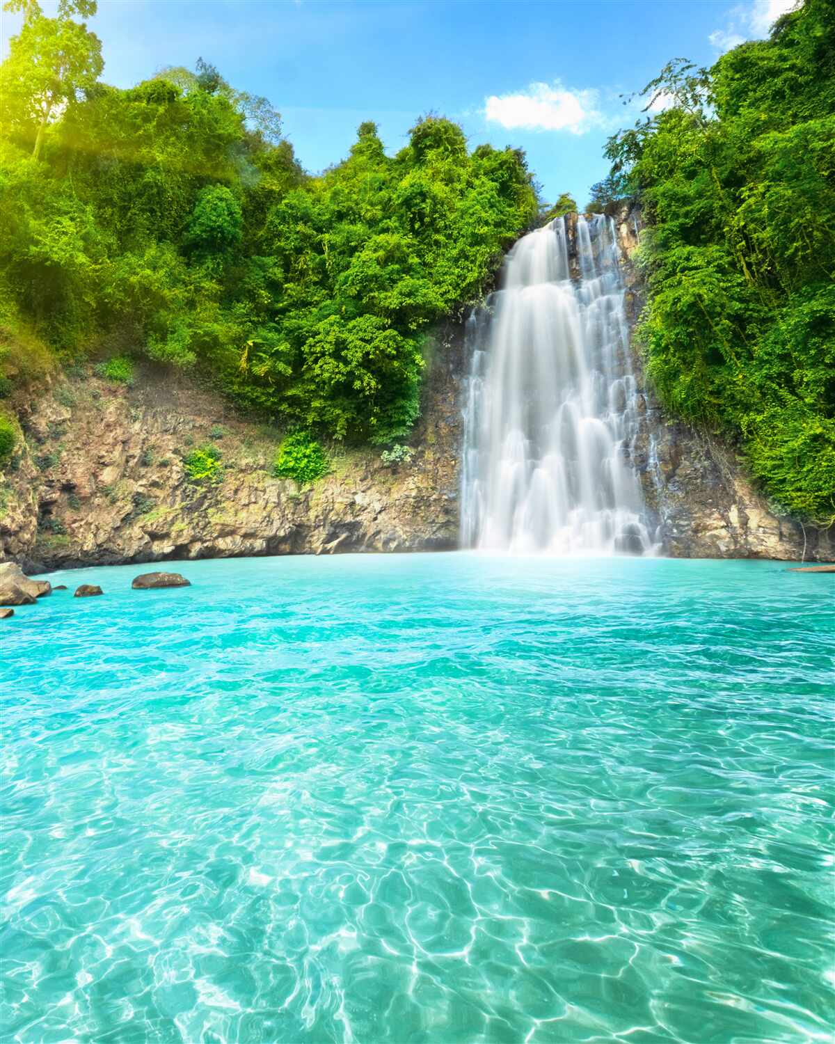 Papier peint une gracieuse cascade se jette dans un lac bleu