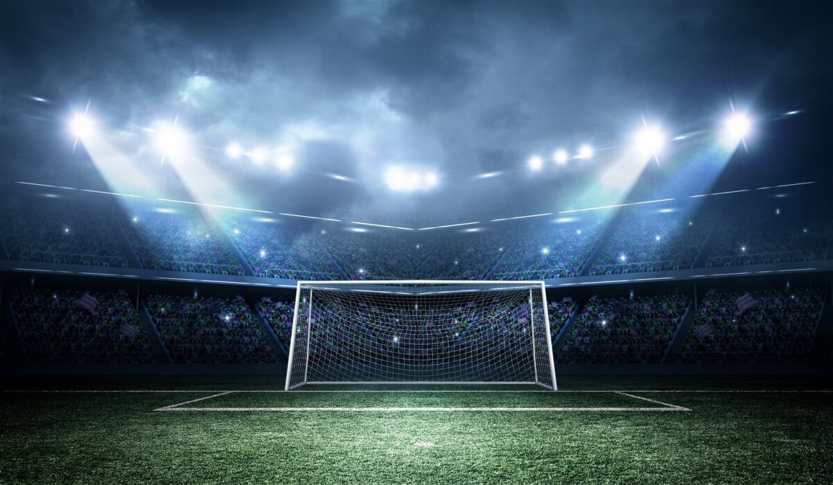Papier peint terrain de football éclairé par des projecteurs